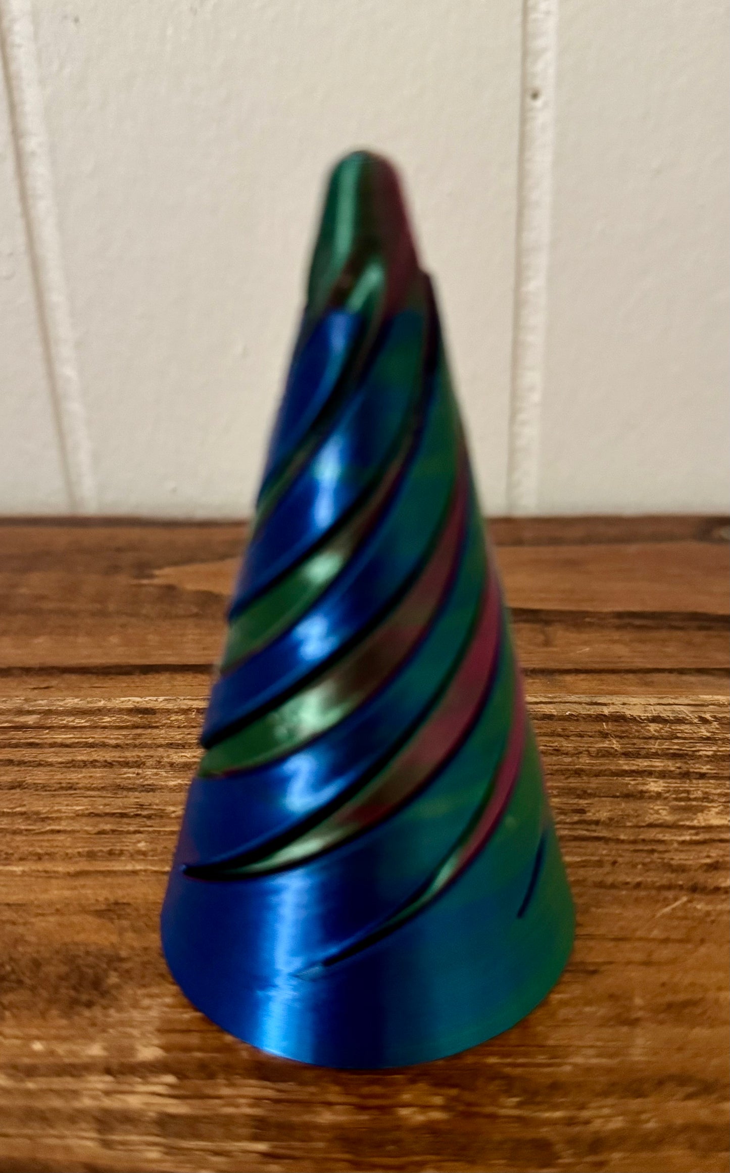 Colorful striped cone-shaped object on a wooden surface