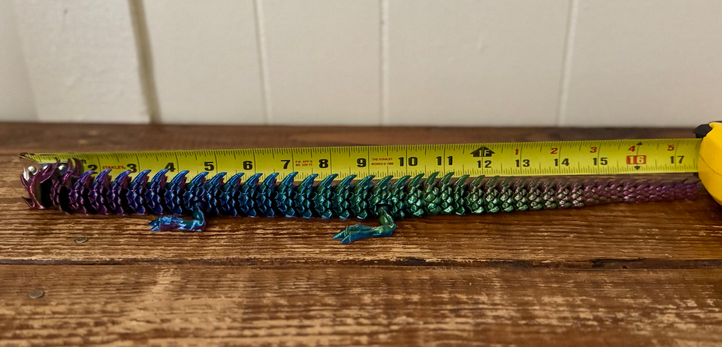 Colorful object on a wooden surface with a tape measure for scale.