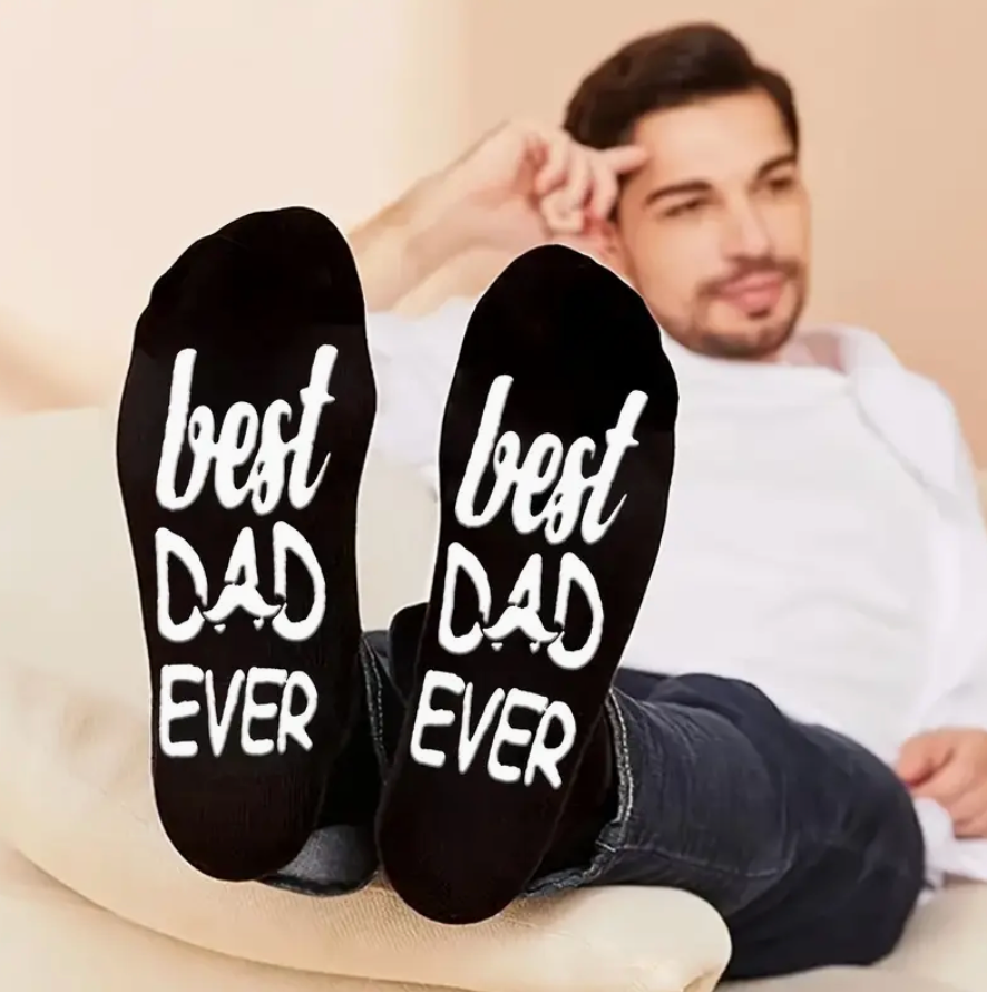 Pair of black socks that say Best Dad Ever, packaged with a free bookmark for Father's Day