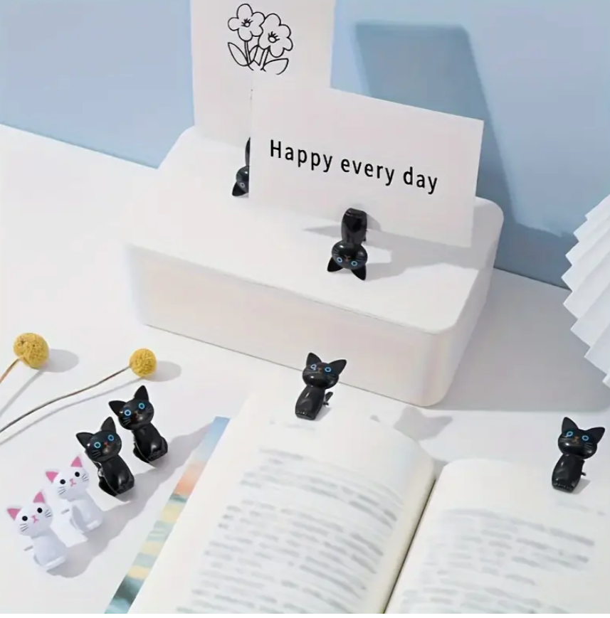Black cat-shaped bookmarks on a stand with 'Happy every day' card on a light blue background