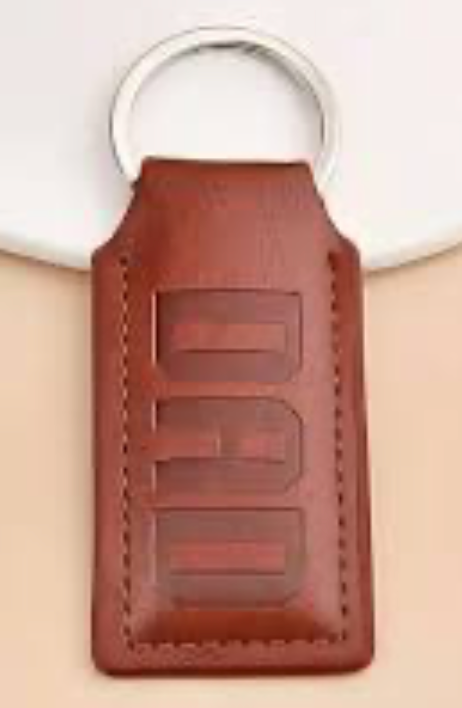 Brown faux leather keychain embossed with the word DAD, minimalist and durable design