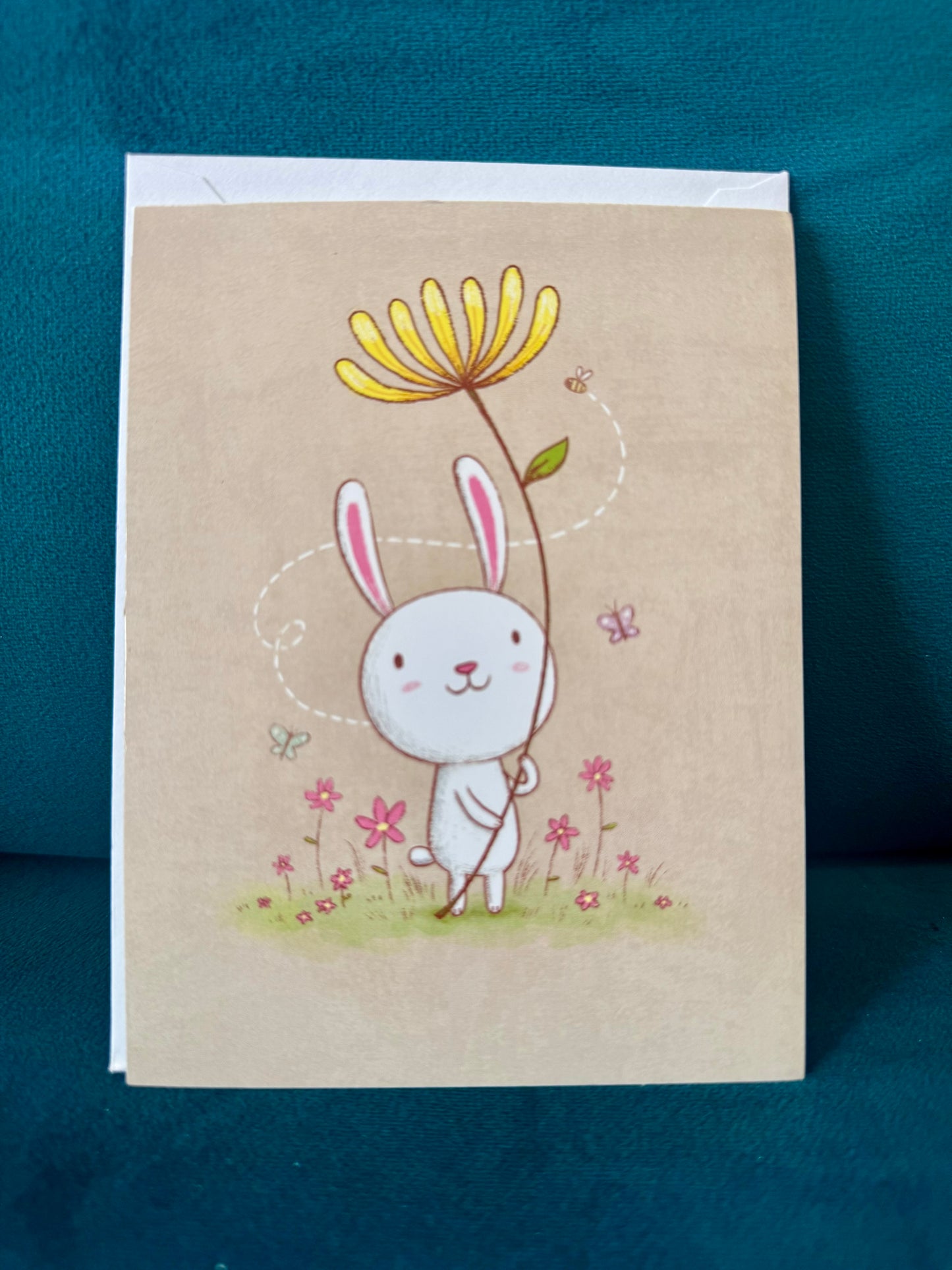 Illustrated notecard featuring a bunny holding a flower—blank inside, measuring 5 by 3.75 inches, perfect for spring notes or everyday greetings.