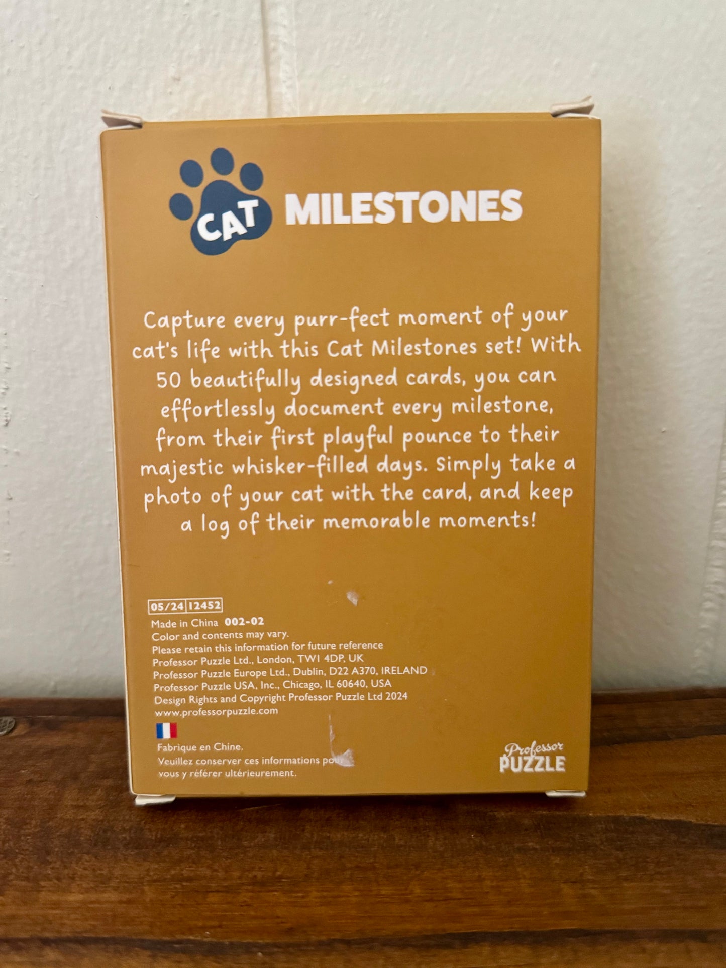 Set of 20 illustrated Cat Milestone Cards displayed on a wooden surface, each depicting different feline milestones