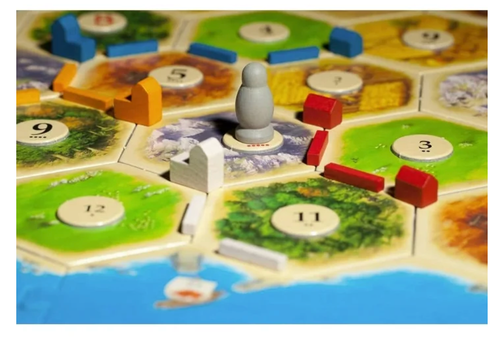 Board game piece on a colorful board with hexagonal tiles