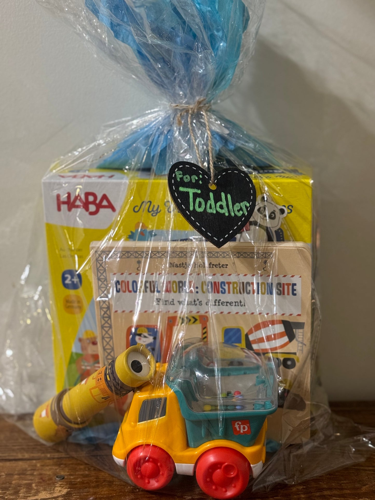 Construction-themed toddler gift basket featuring a board book, toy truck, and My Very First Games: Building Site game.