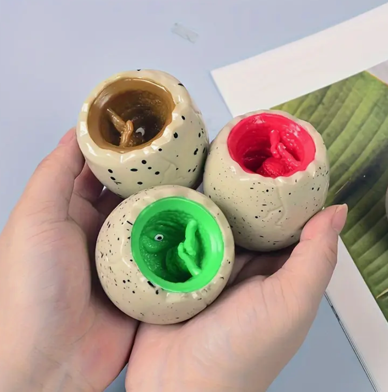Three small ceramic pots with colorful candle wax inside, held by a hand against a light background.