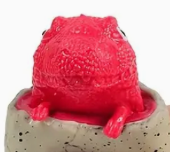 Red frog figurine on a textured stone base