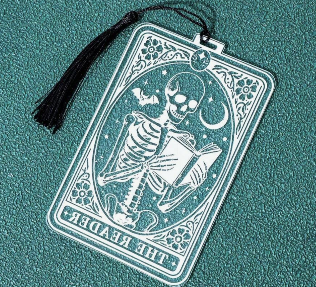 Decorative bookmark with skeleton design on a teal background