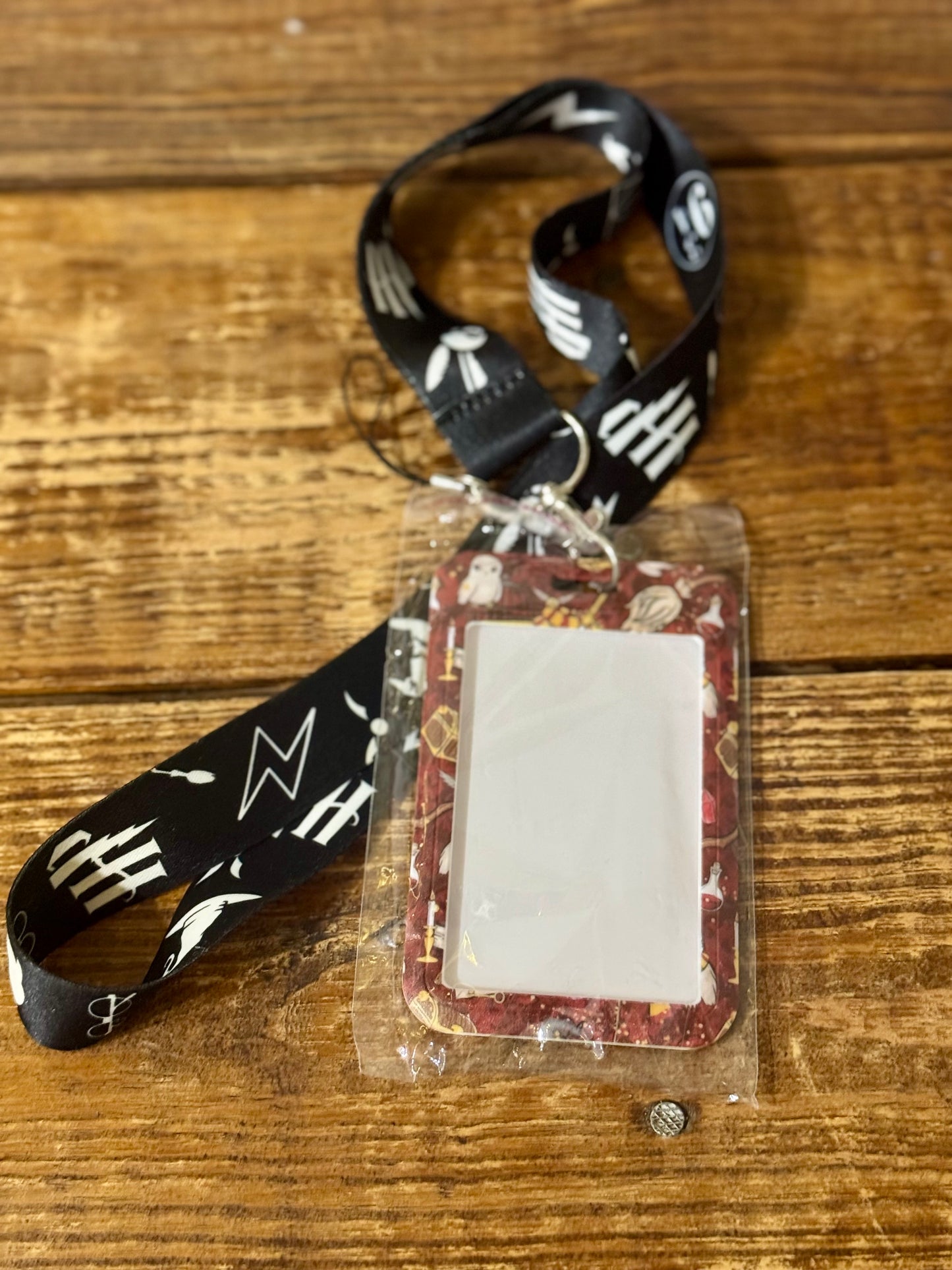 Harry Potter-themed lanyard with attached decorated hard ID case, featuring iconic symbols from the wizarding world.