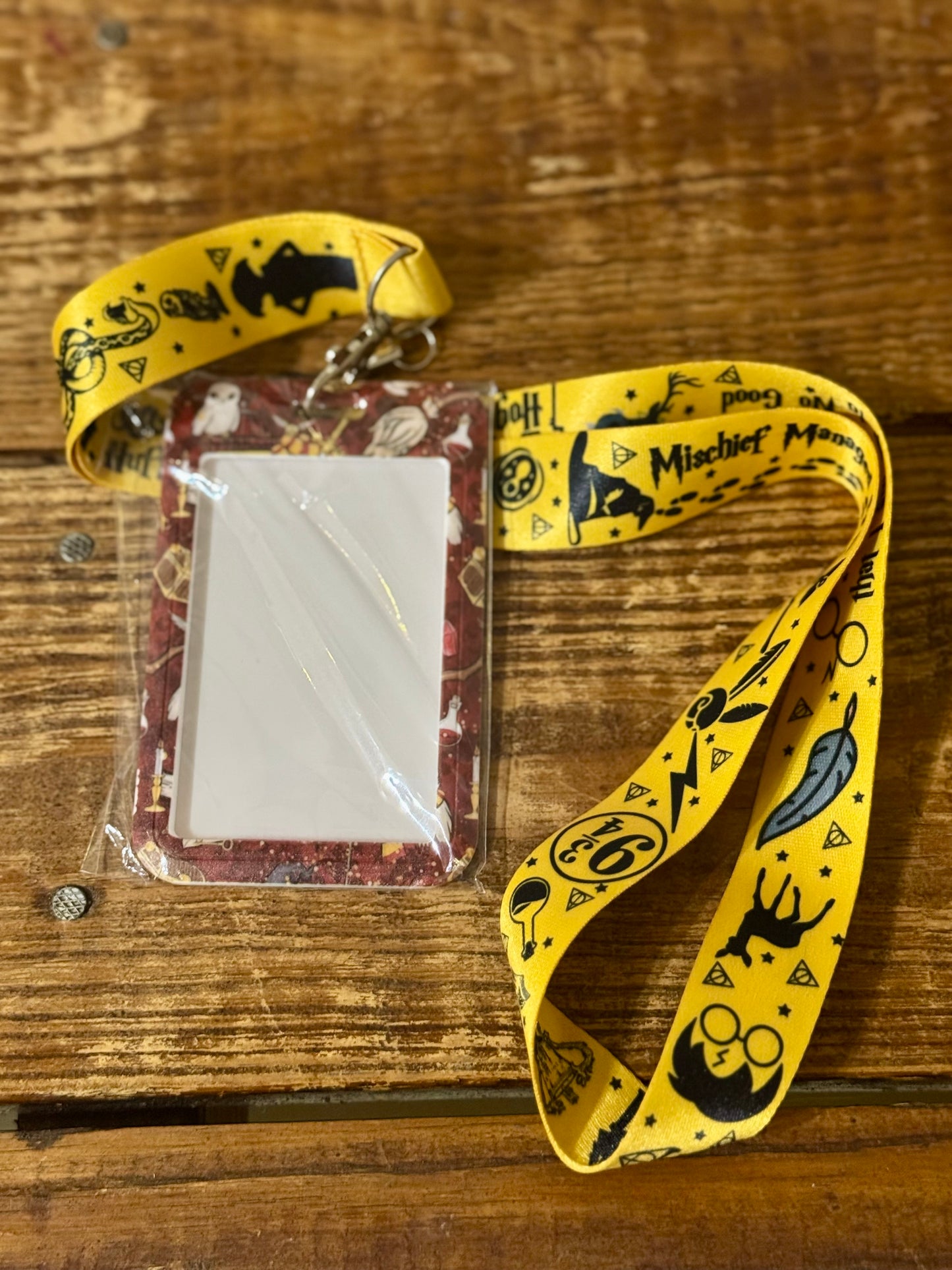 Harry Potter-themed lanyard with attached decorated hard ID case, featuring iconic symbols from the wizarding world.