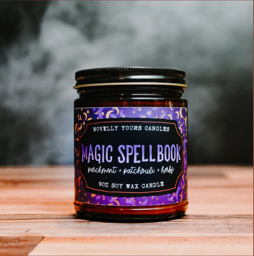 Candle jar labeled 'Magic Spellbook' on a wooden surface with a dark background