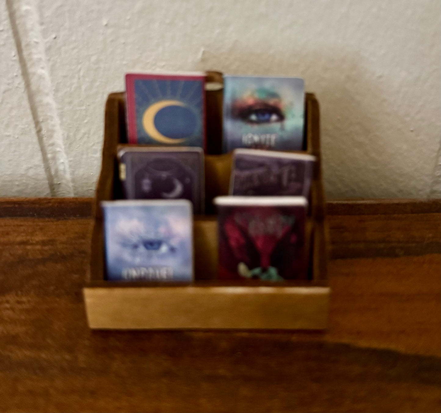 Set of trading cards in a wooden holder on a textured surface with a neutral background