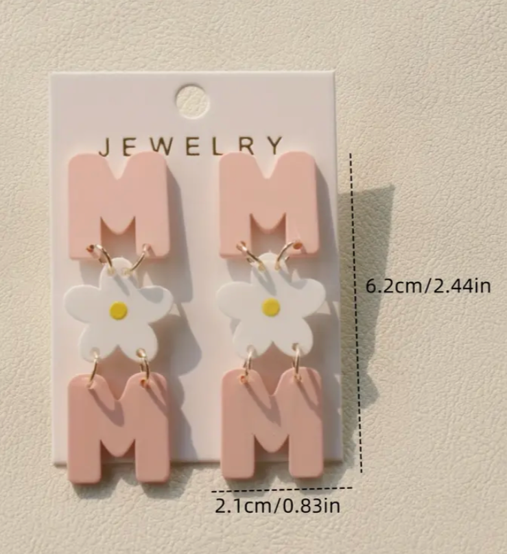 Jewelry card with pink letter 'M' and flower earrings on a beige background