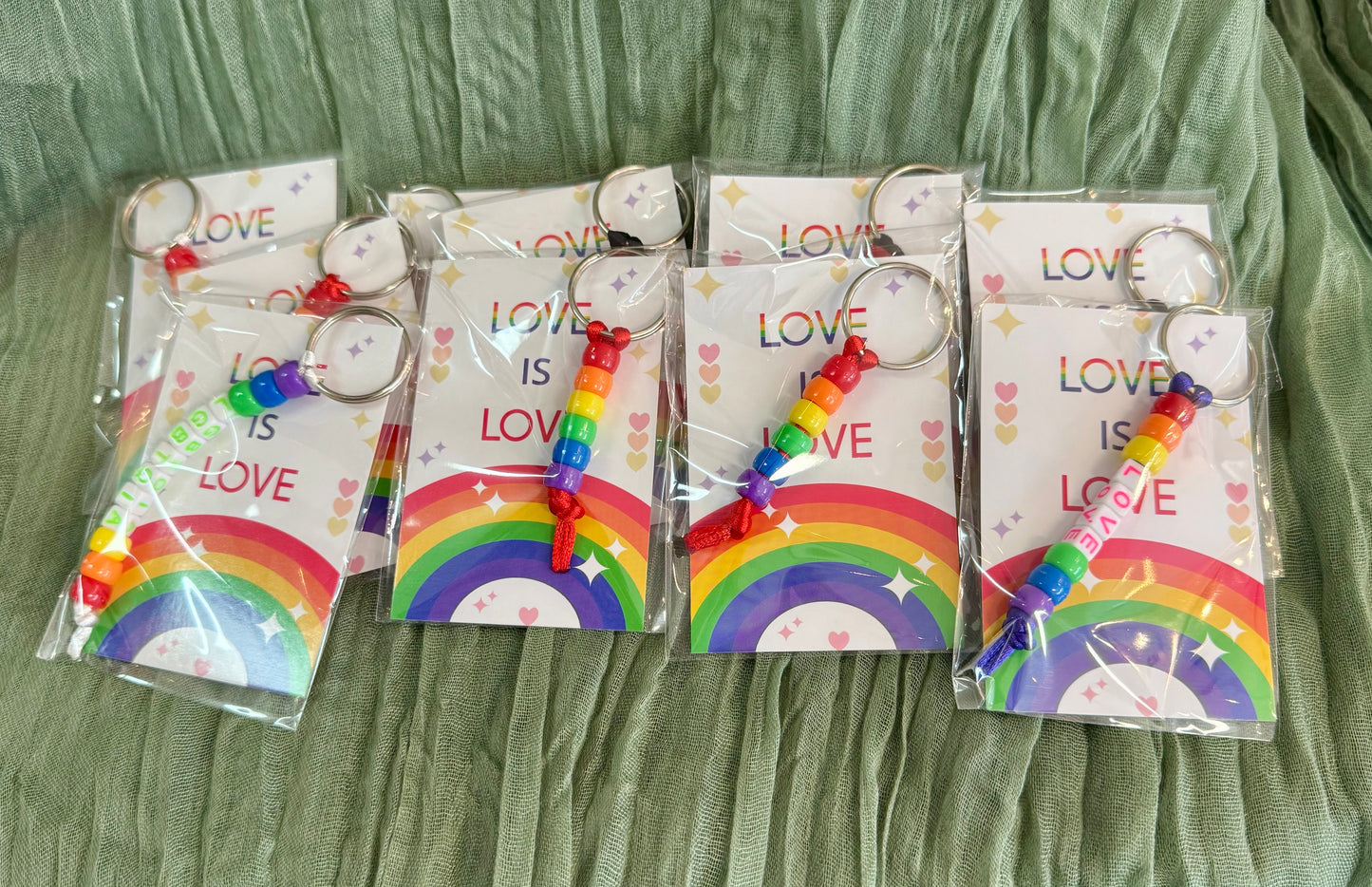 Beaded rainbow Pride keychain with word bead charms like Pride and Love on a Love is Love card