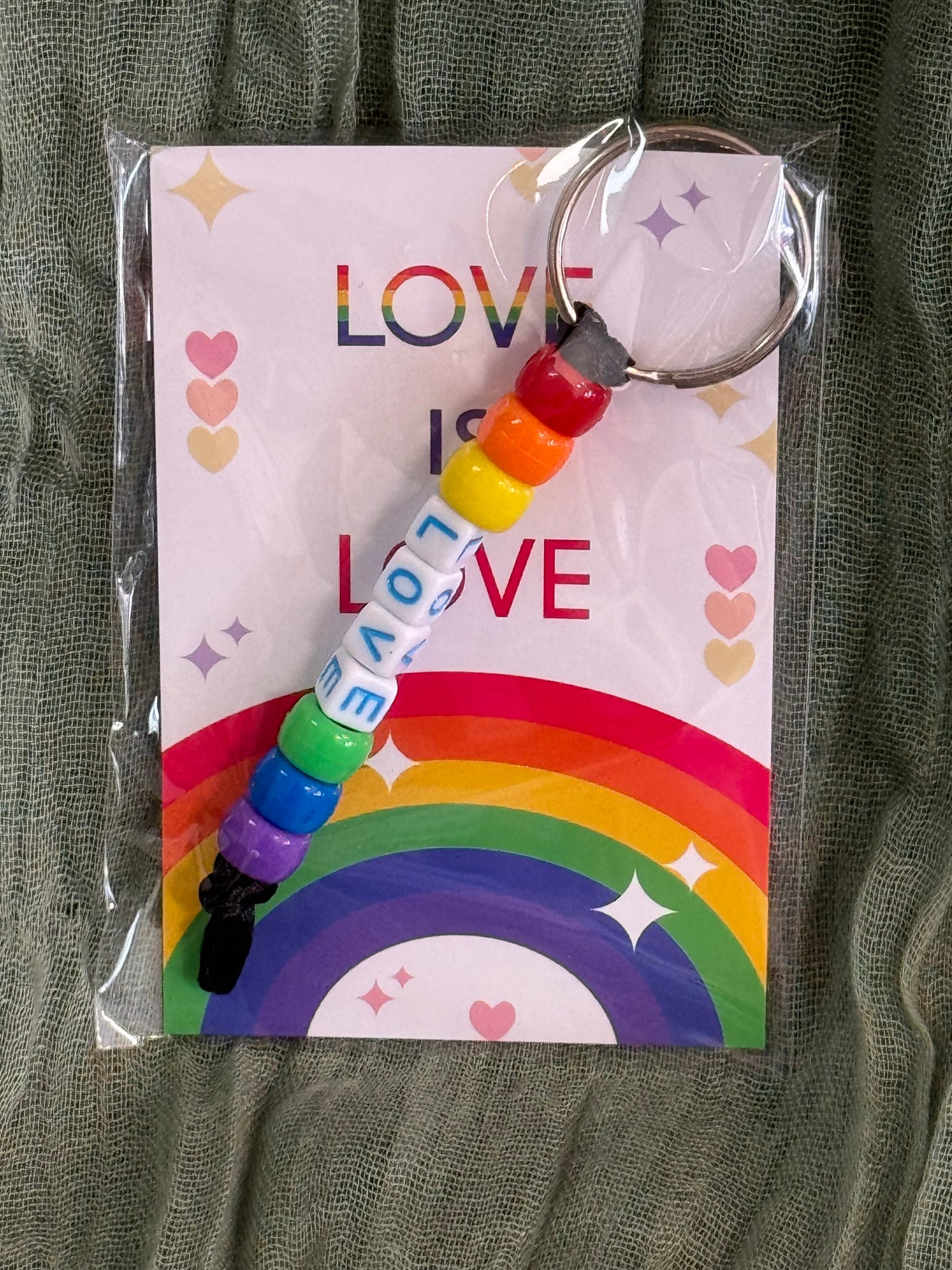 Beaded rainbow Pride keychain with word bead charms like Pride and Love on a Love is Love card