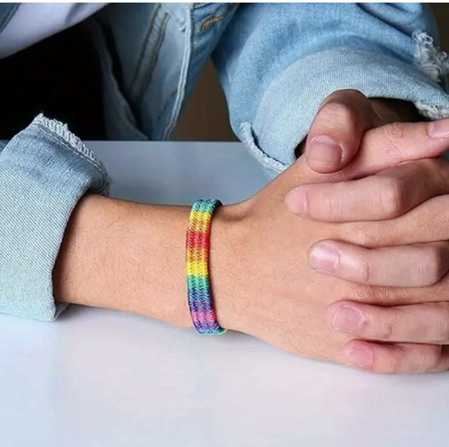 Woven rainbow polyester bracelet with adjustable ends, representing LGBTQ+ Pride