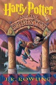 Front cover of Harry Potter and the Sorcerer’s Stone by J.K. Rowling, featuring Harry flying on a broomstick with Hogwarts in the background.