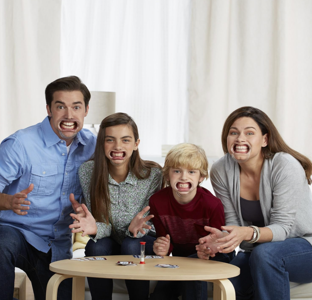 Four people sitting together in a living room with a table in front of them.