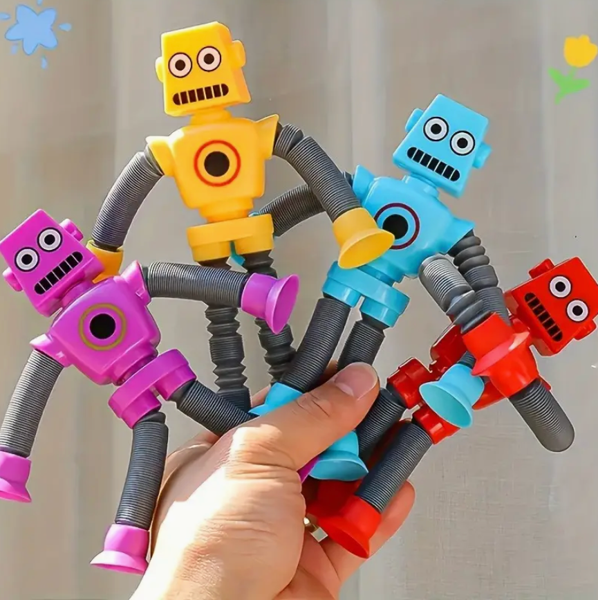 Colorful toy robots held by a hand against a neutral background