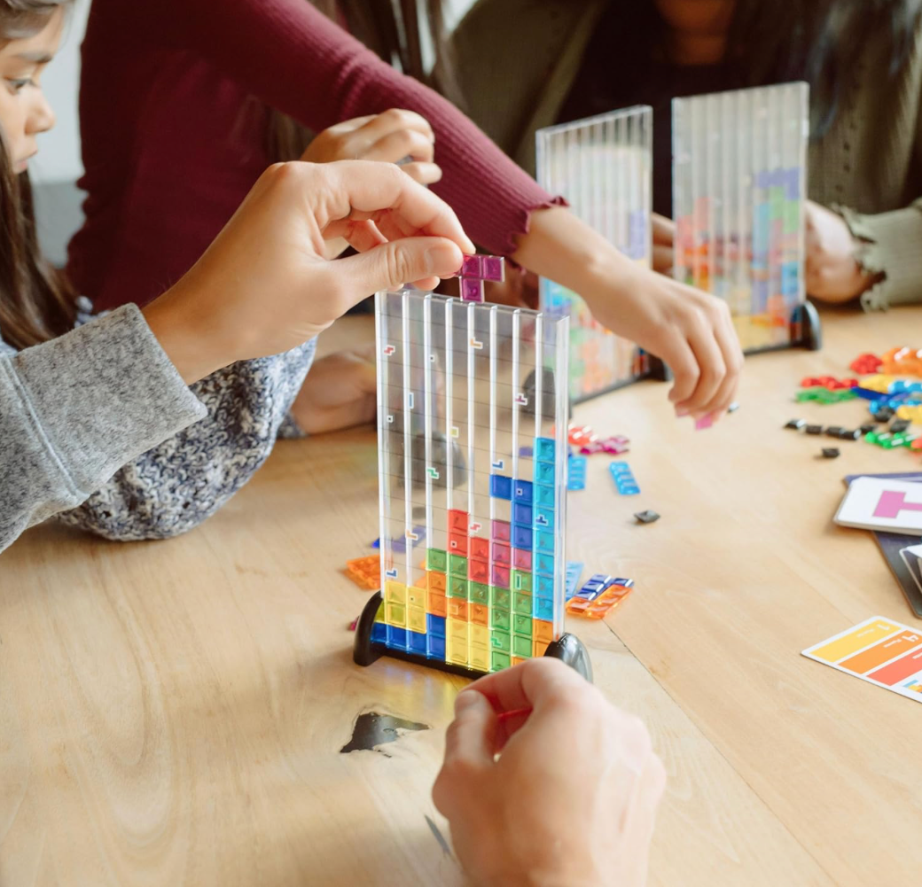 Children playing with colorful building blocks on a wooden table