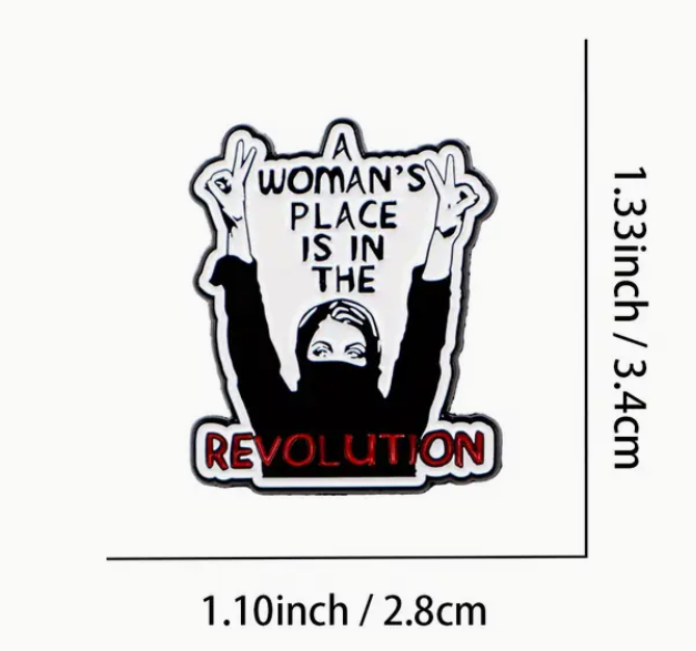 A Woman’s Place Is in the Revolution enamel pin with bold lettering, feminist empowerment accessory for jackets and bags