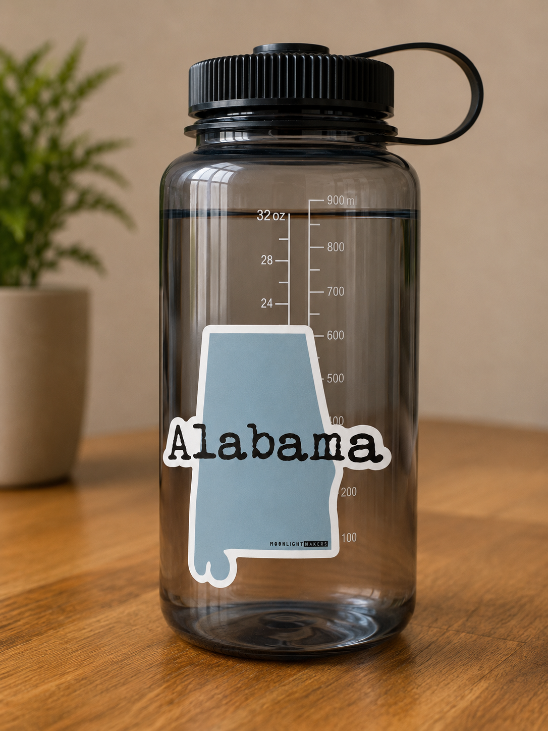 Light blue Alabama state-shaped vinyl sticker with Alabama written across the center displayed on a water bottle.
