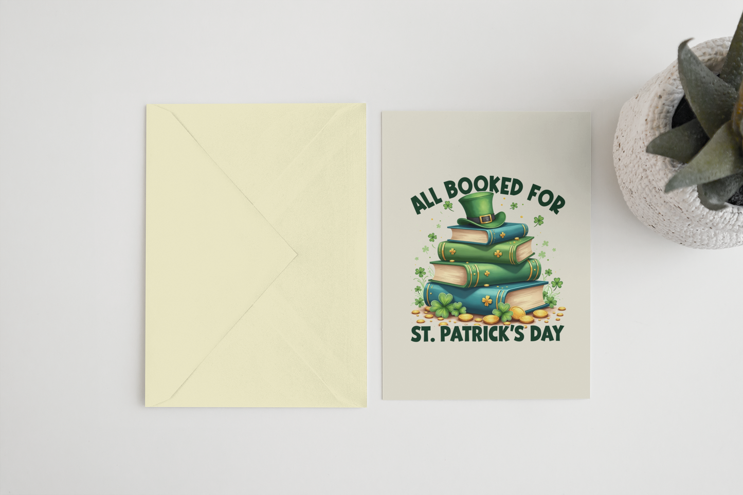 A festive book-themed notecard featuring the phrase All Booked for St. Patrick’s Day with an illustration of a stack of books topped with a leprechaun hat.