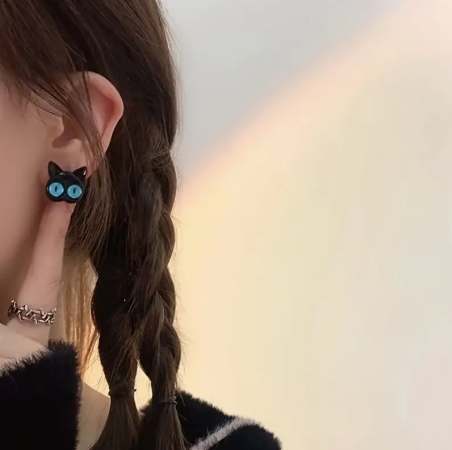 Pair of black cat earrings featuring large blue eyes, a playful and lightweight accessory perfect for cat lovers and everyday wear.