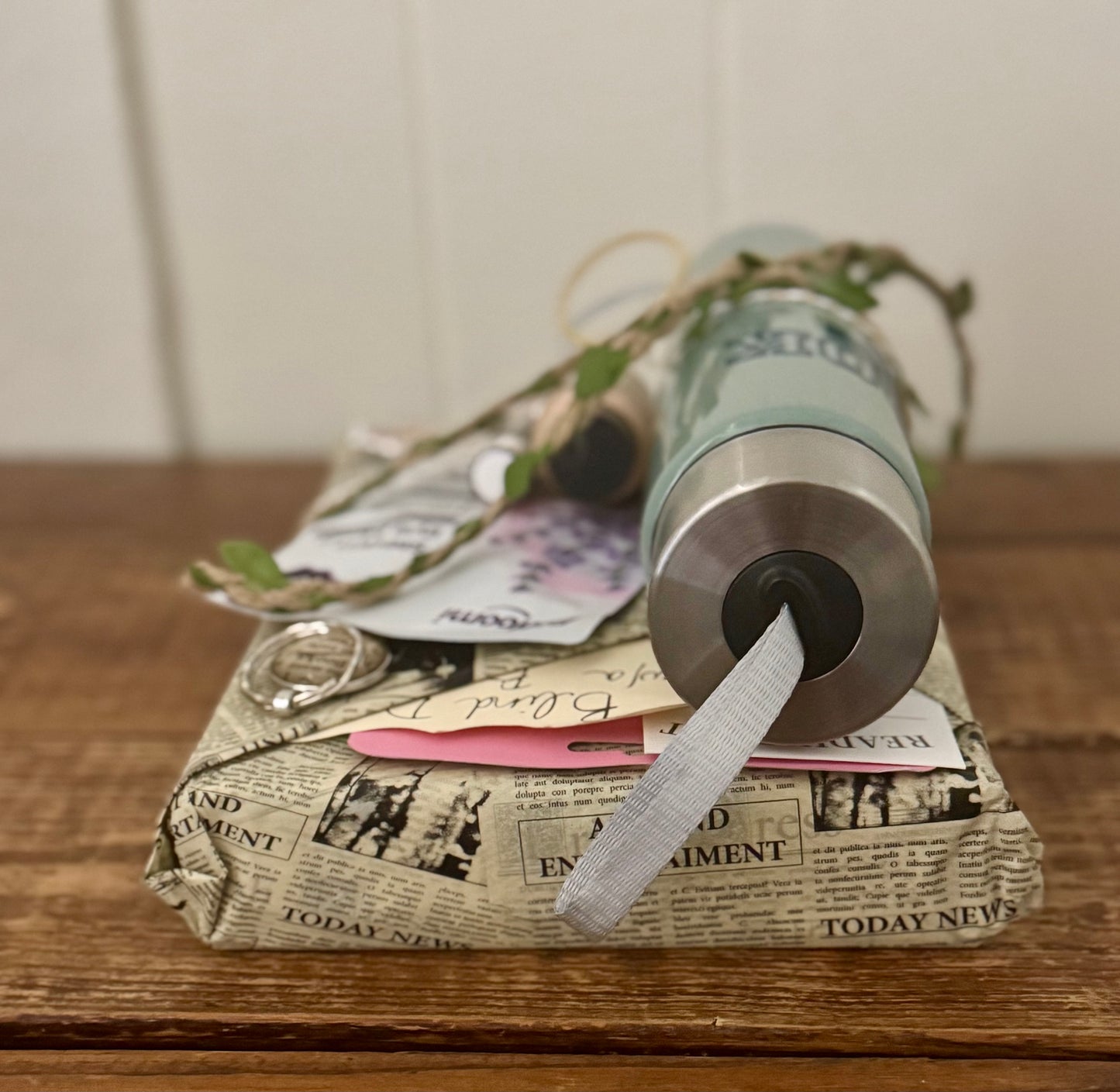 Roll of toilet paper wrapped in newspaper on a wooden surface