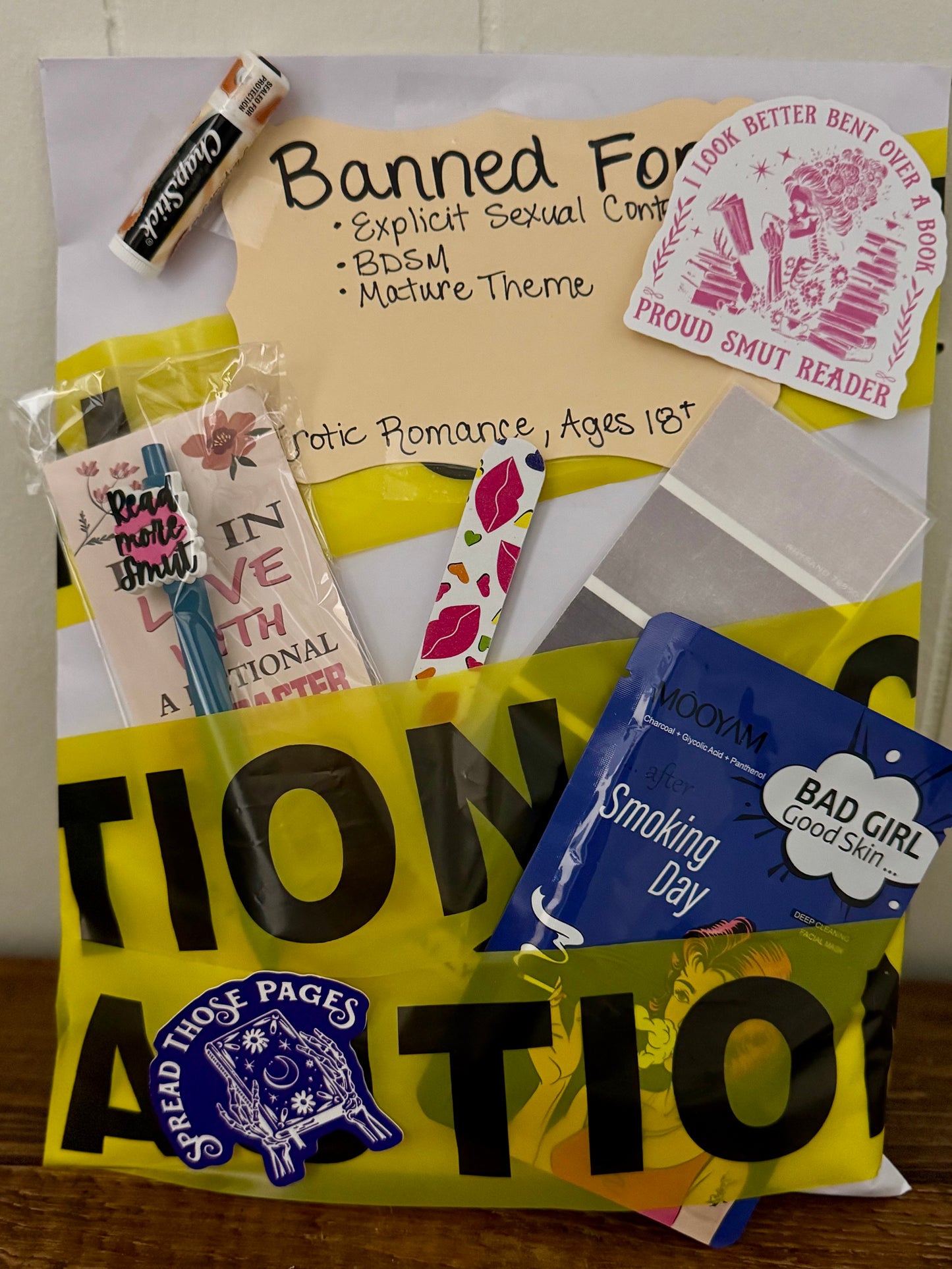 Collection of books and items with various labels and stickers on a yellow background