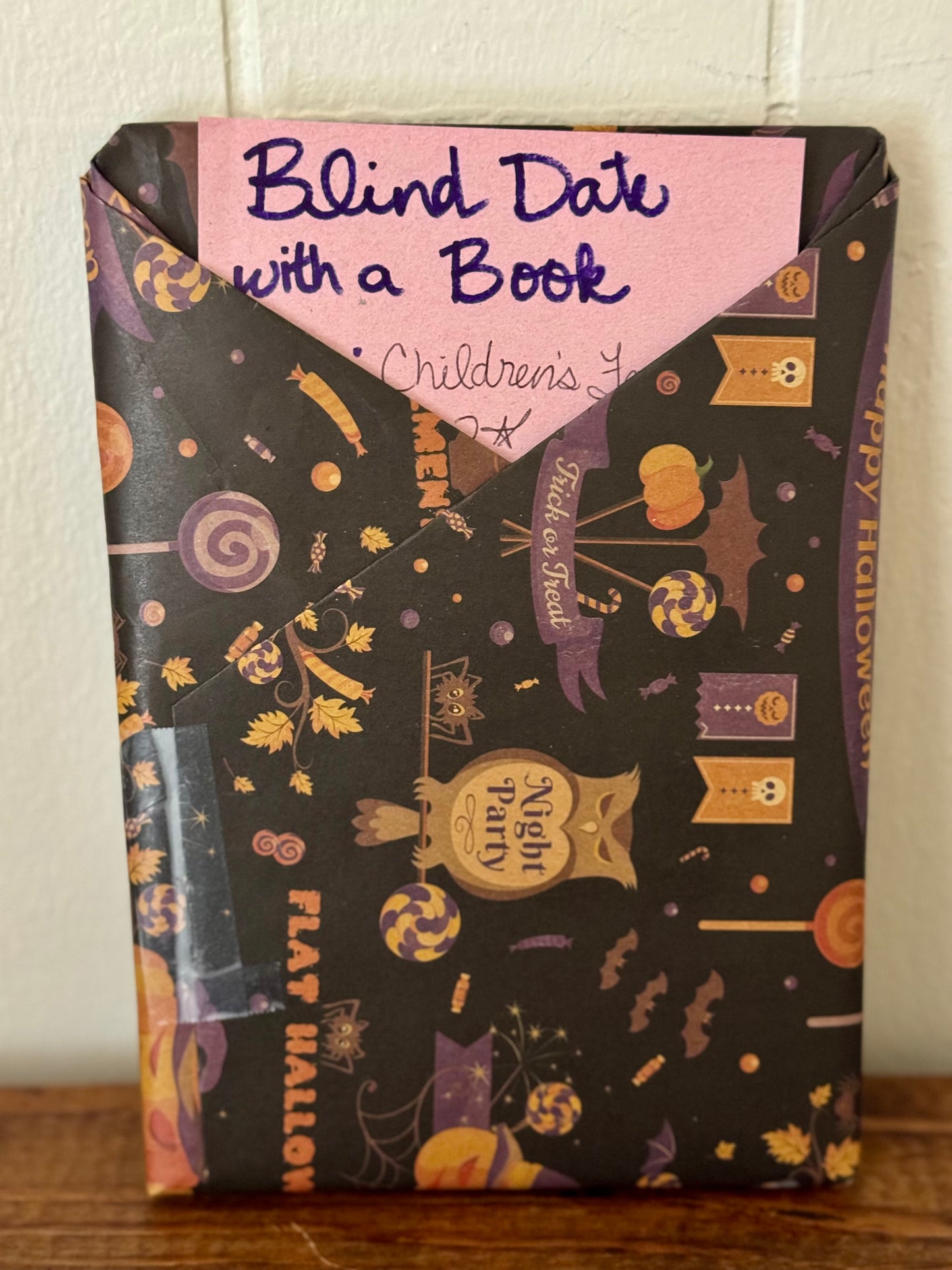 Packaged children's books with Halloween-themed design on a wooden surface.
