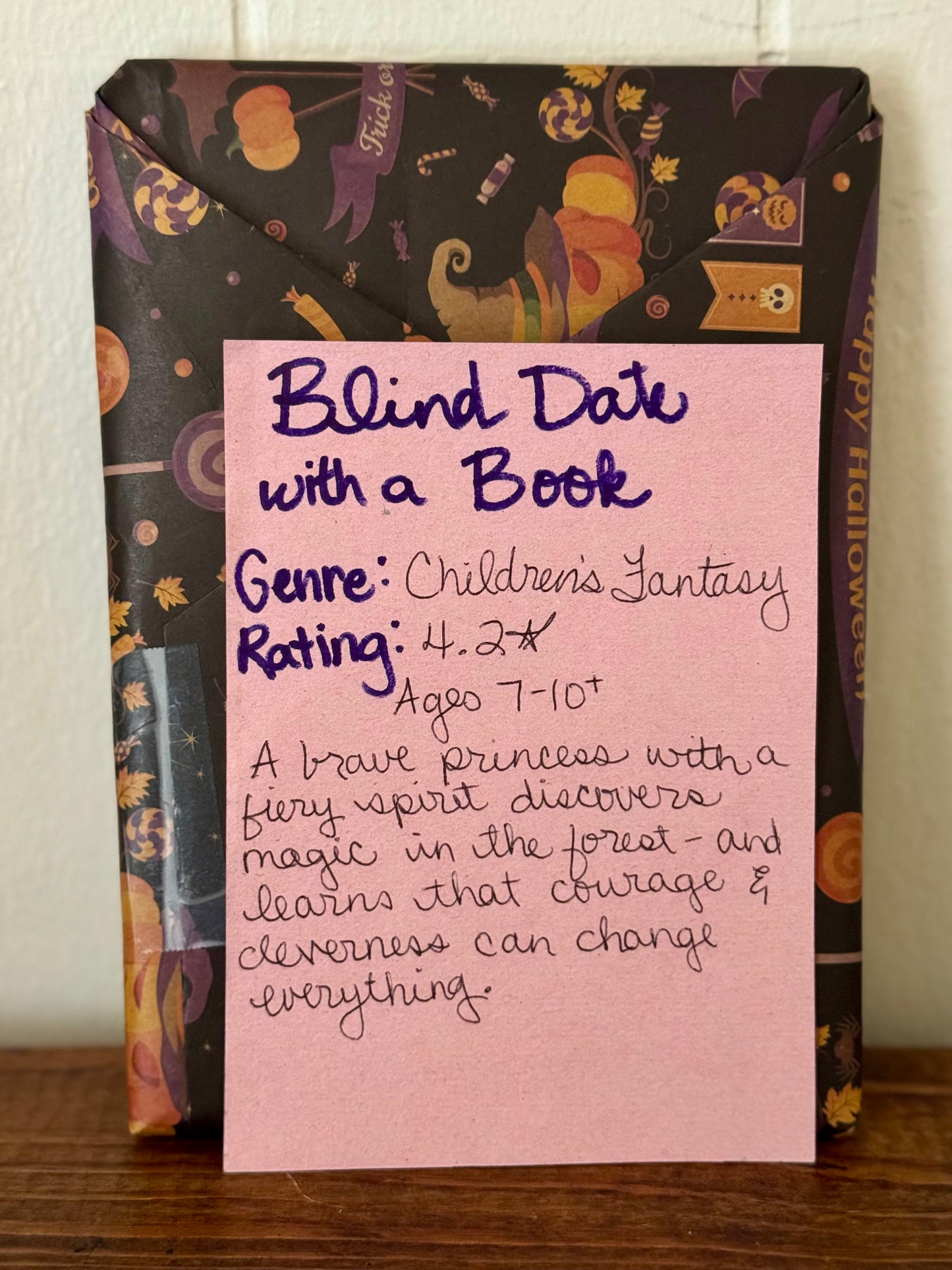 Packaged children's books with Halloween-themed design on a wooden surface.