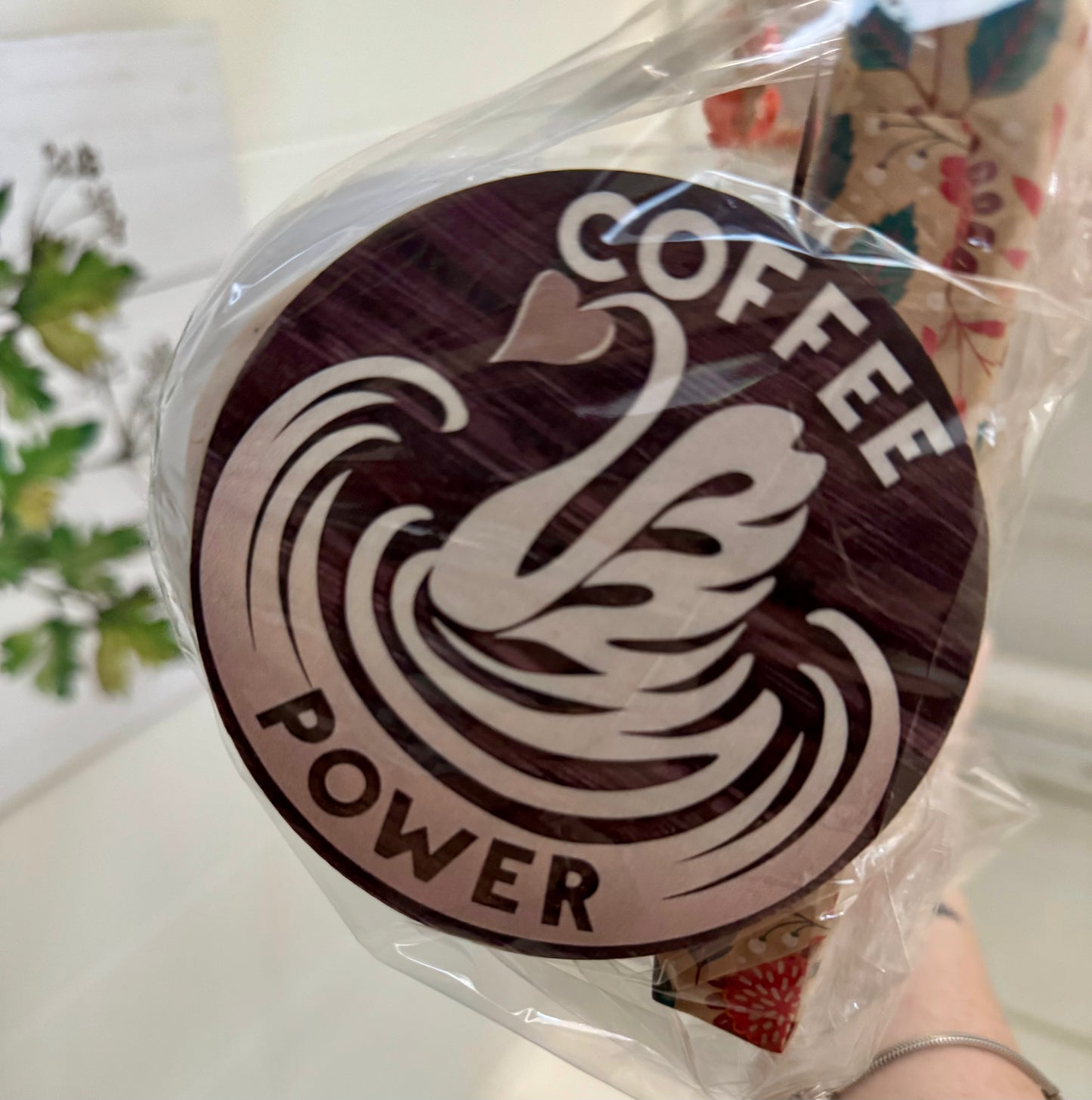 Circular sign with 'Coffee Power' text and coffee bean design, wrapped in clear plastic.