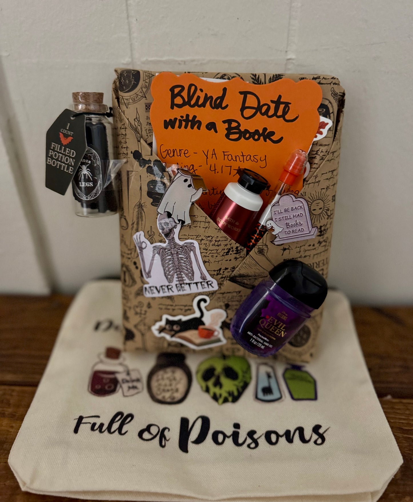 Book-themed gift set with a tote bag labeled 'Full of Poisons' on a wooden surface.
