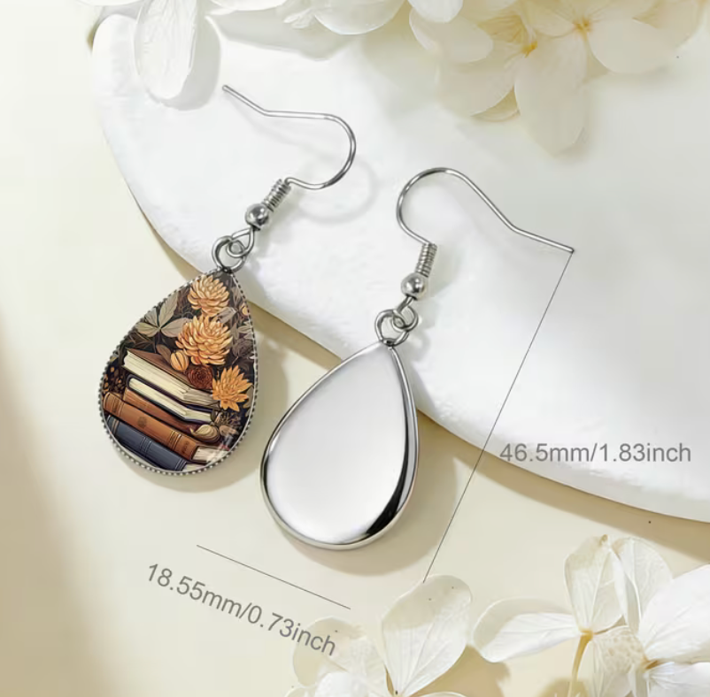 Book stack and golden flower teardrop glass earring with silver-tone hook measuring approximately 1.83 inches long