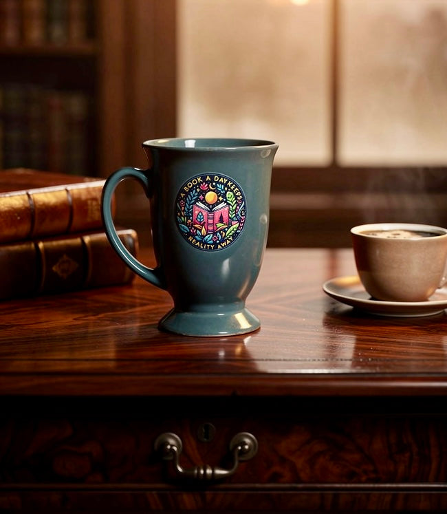 Bookish coffee mug with A Book a Day Keeps Reality Away design displayed on a wooden desk beside books and a cup of coffee