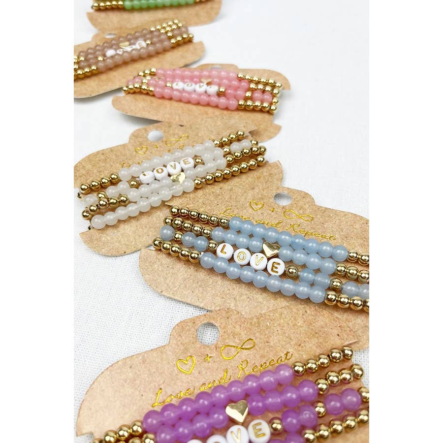 Handmade beaded bracelet with colorful beads and the word "LOVE" spelled out in white letter beads, perfect for casual wear or gifting.