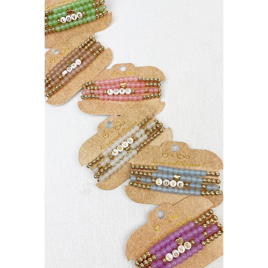 Handmade beaded bracelet with colorful beads and the word "LOVE" spelled out in white letter beads, perfect for casual wear or gifting.
