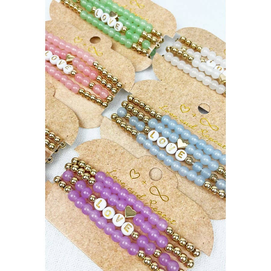 Handmade beaded bracelet with colorful beads and the word "LOVE" spelled out in white letter beads, perfect for casual wear or gifting.