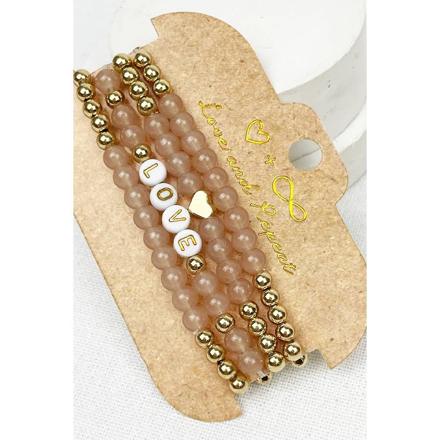 Handmade beaded bracelet with colorful beads and the word "LOVE" spelled out in white letter beads, perfect for casual wear or gifting.