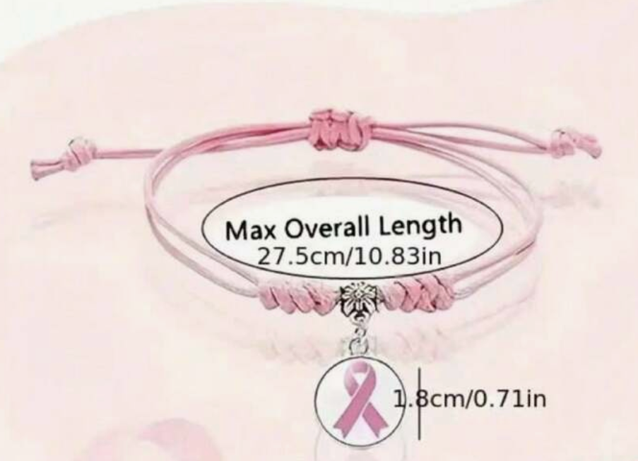 Pink bracelet with a breast cancer awareness ribbon charm on a light pink background