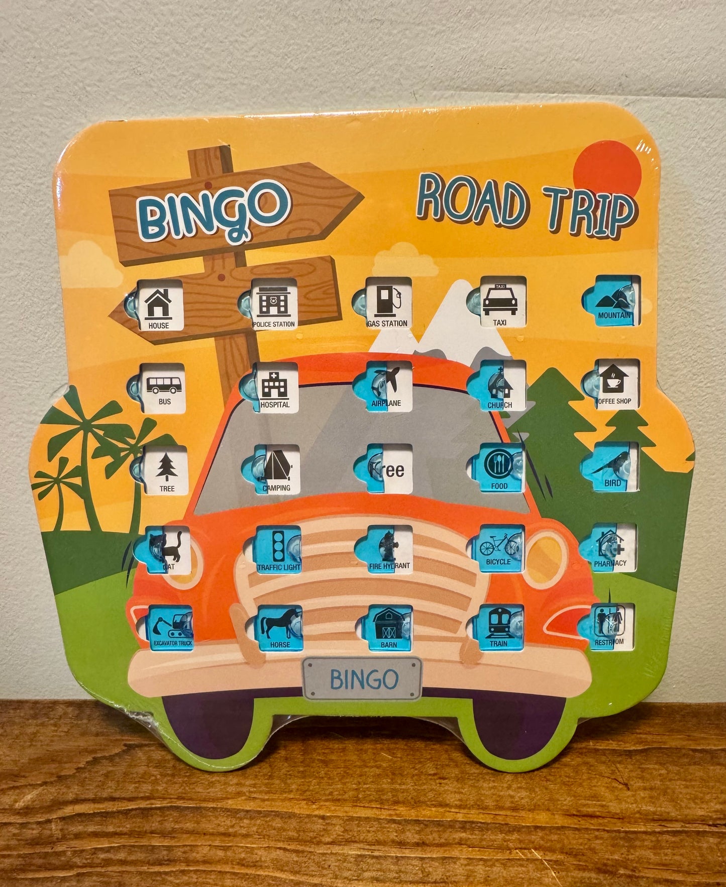 Road trip bingo card featuring colorful icons like stop signs, cows, and airplanes—ideal for kids during long car rides.