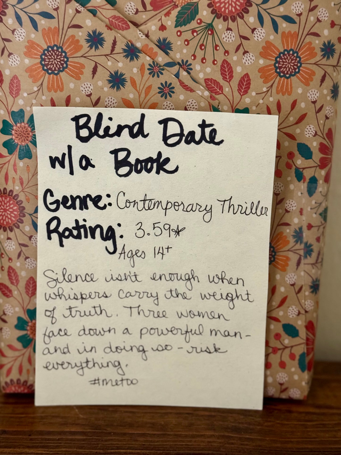Note with 'Blind Date w/ a Book' details on a floral-patterned fabric background