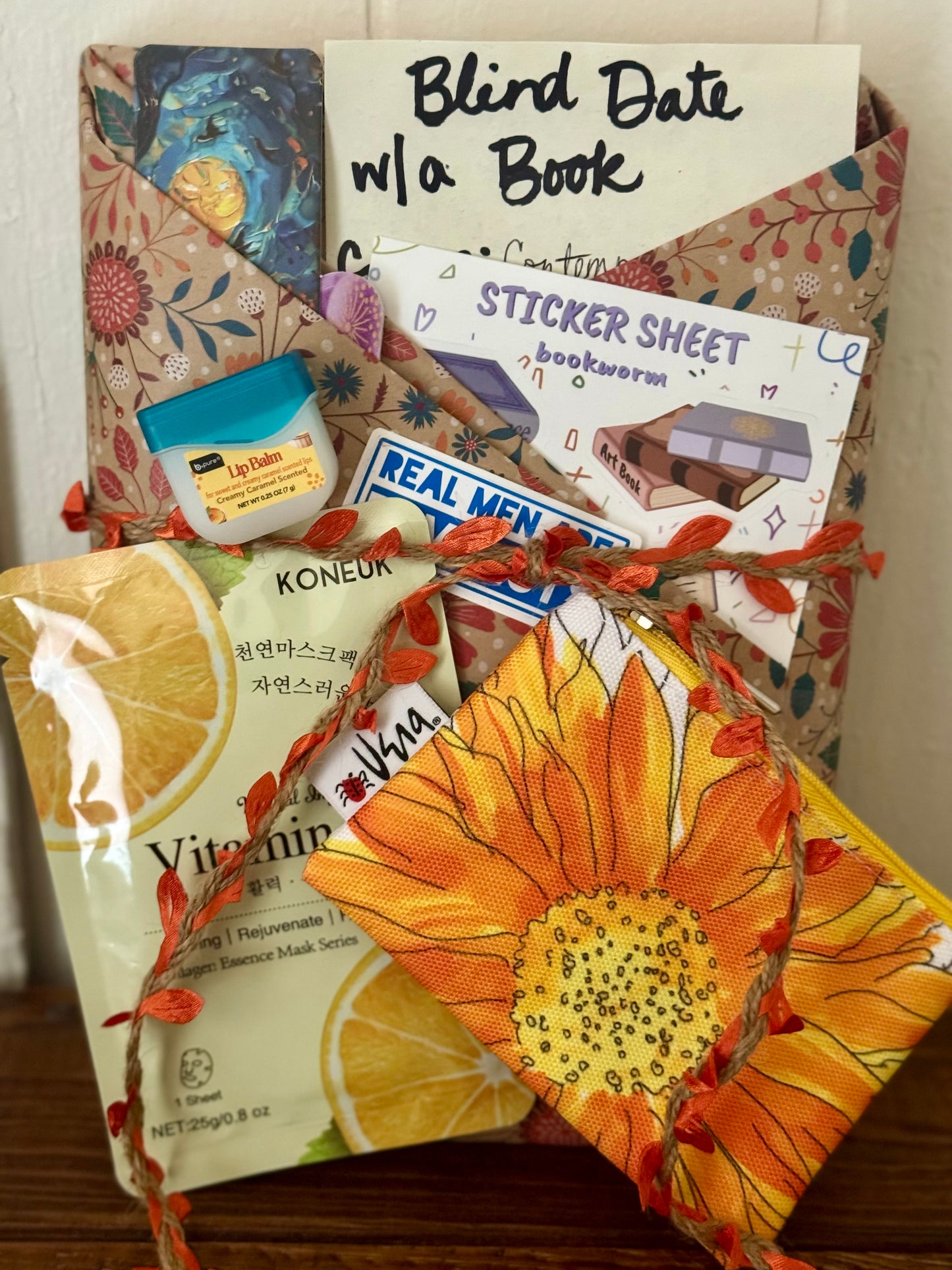 Assorted items including a book, stickers, and snacks on a wooden surface.