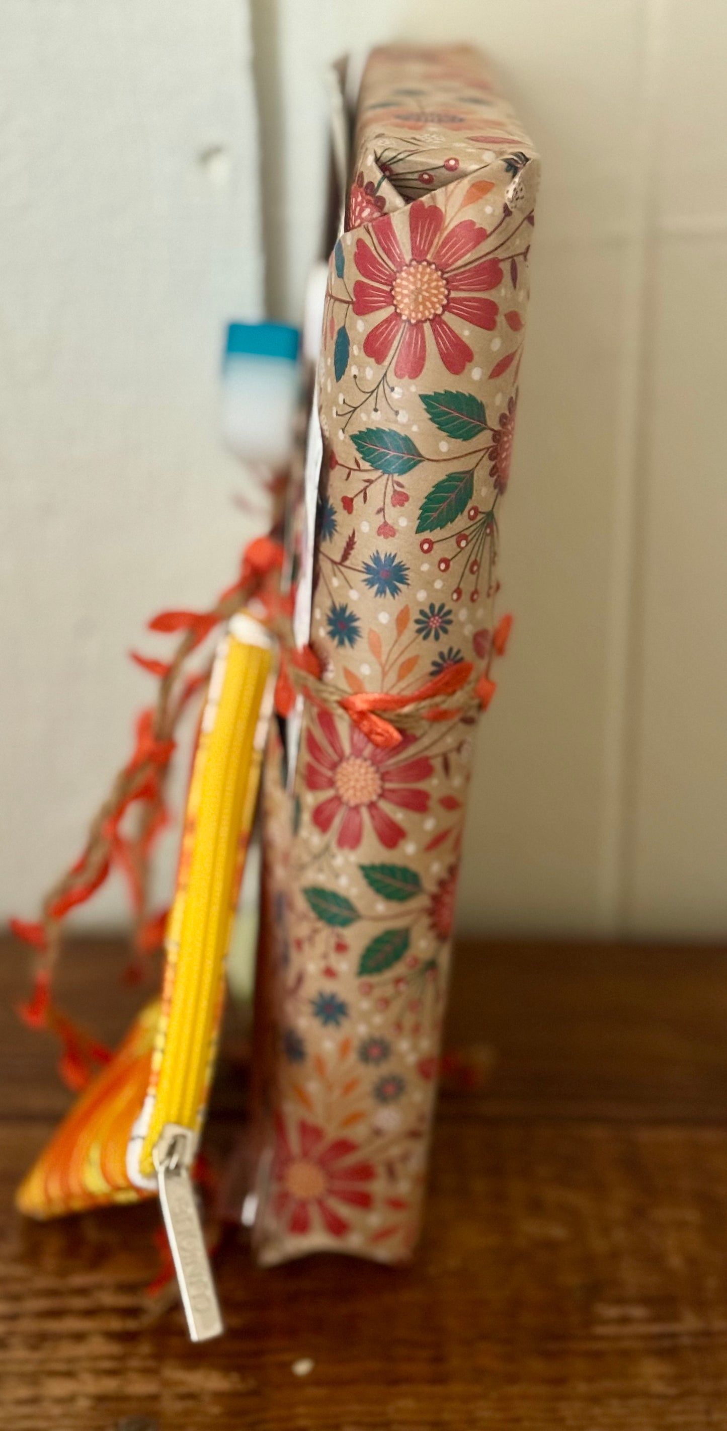 Floral-patterned box with a yellow pen on a wooden surface