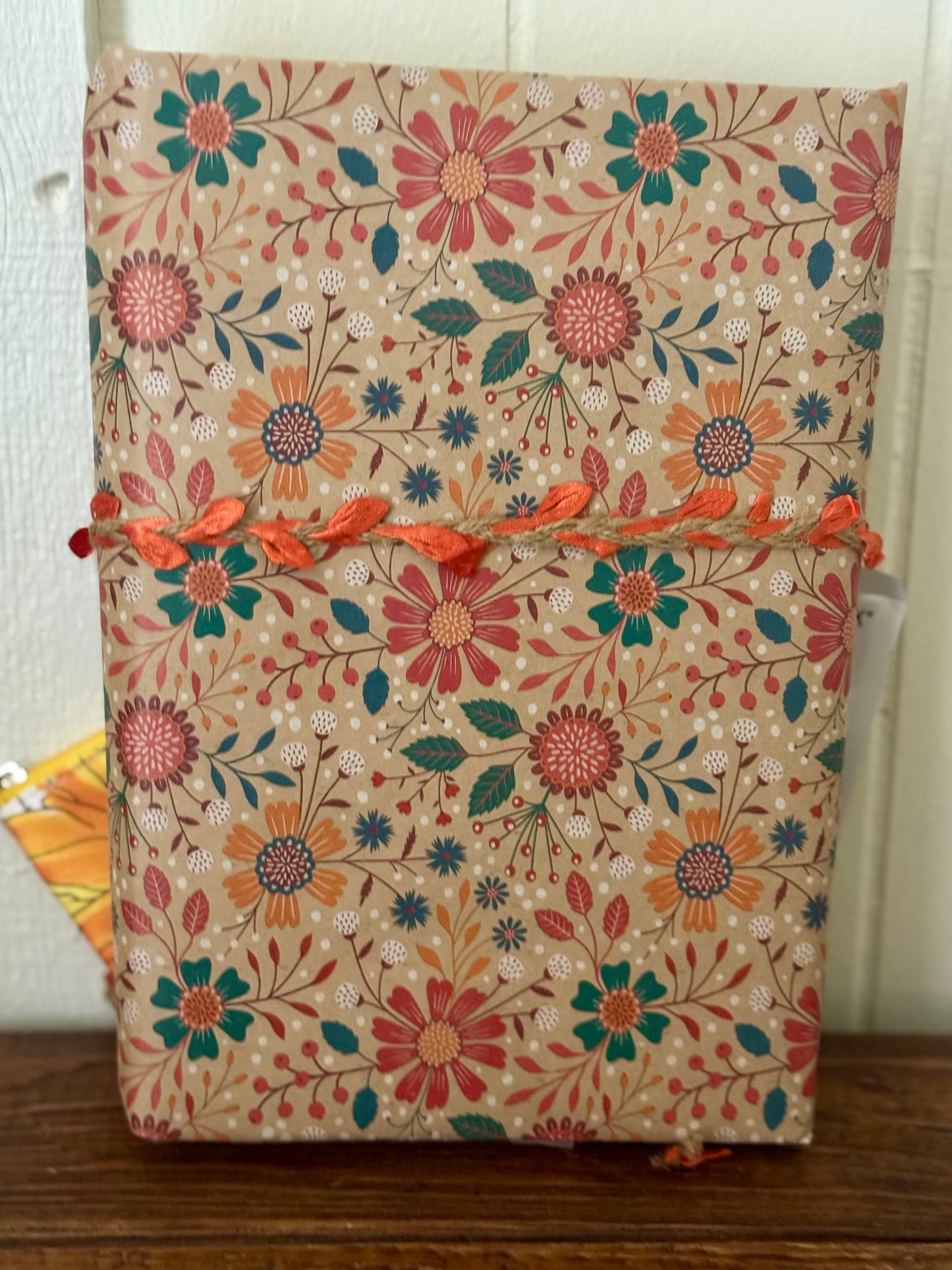 Floral-patterned fabric with orange accents on a wooden surface