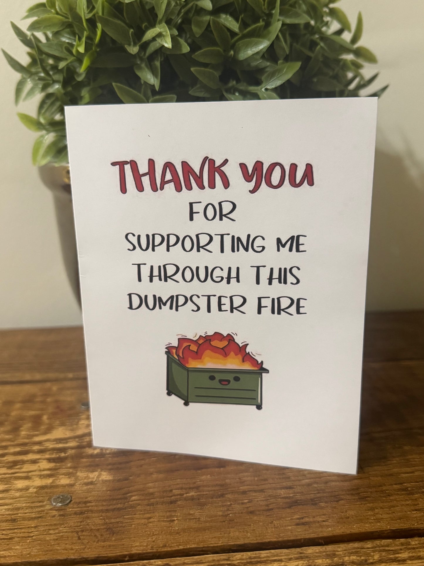 A humorous thank-you card featuring the phrase Thank You for Supporting Me Through This Dumpster Fire, perfect for showing appreciation with a touch of humor.
