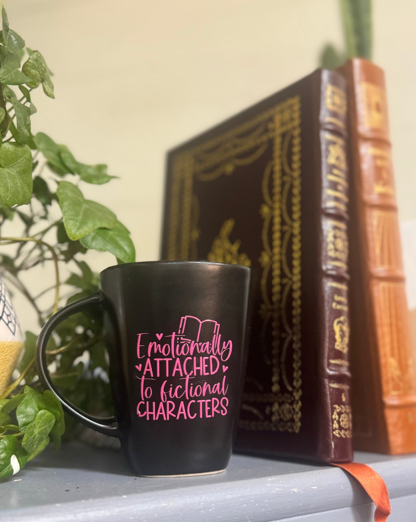 Ceramic coffee mug with the phrase Emotionally Attached to Fictional Characters, perfect for readers and story lovers.