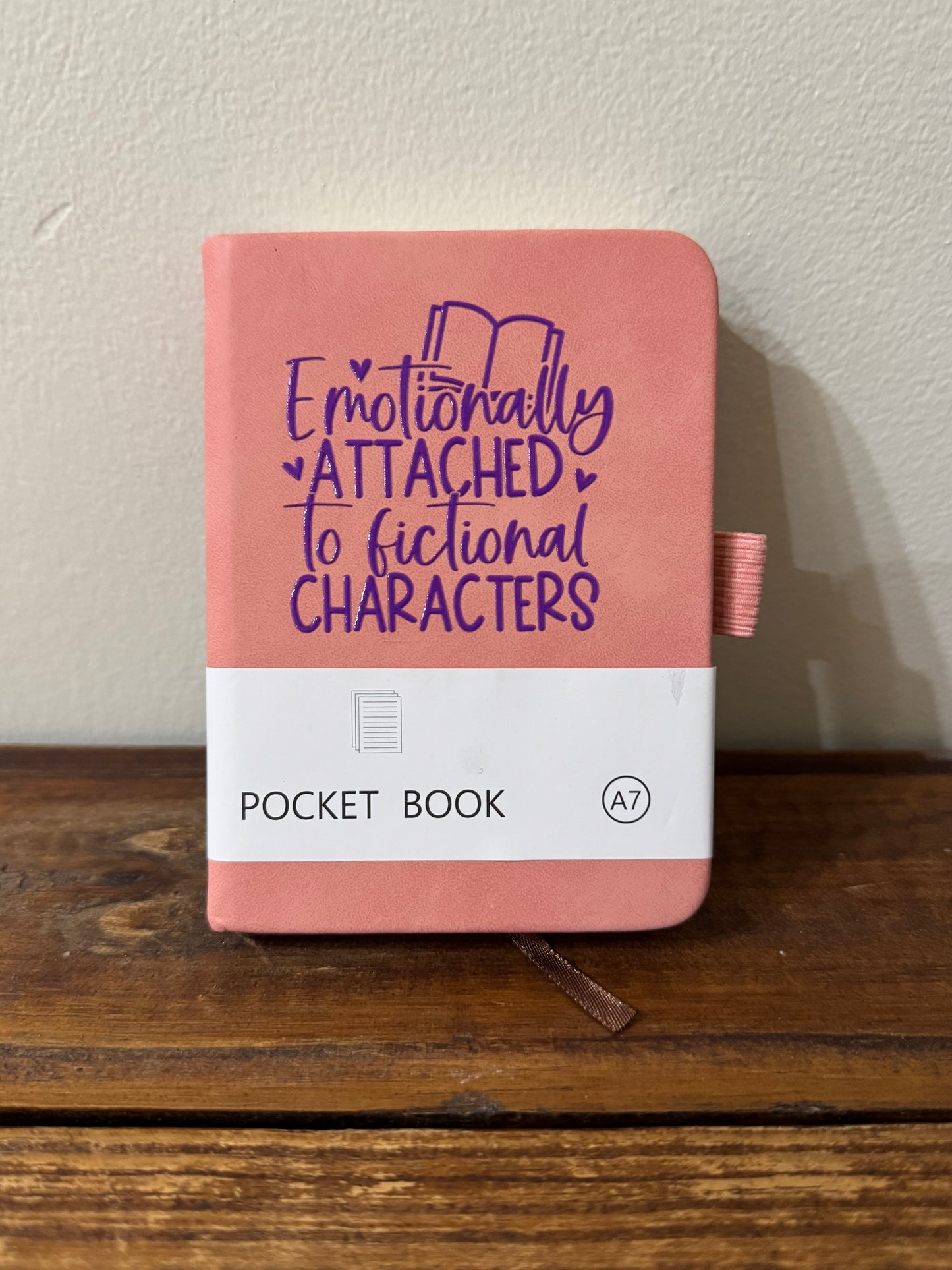 Pocket notebook with the phrase Emotionally Attached to Fictional Characters, ideal for book lovers and jotting ideas."