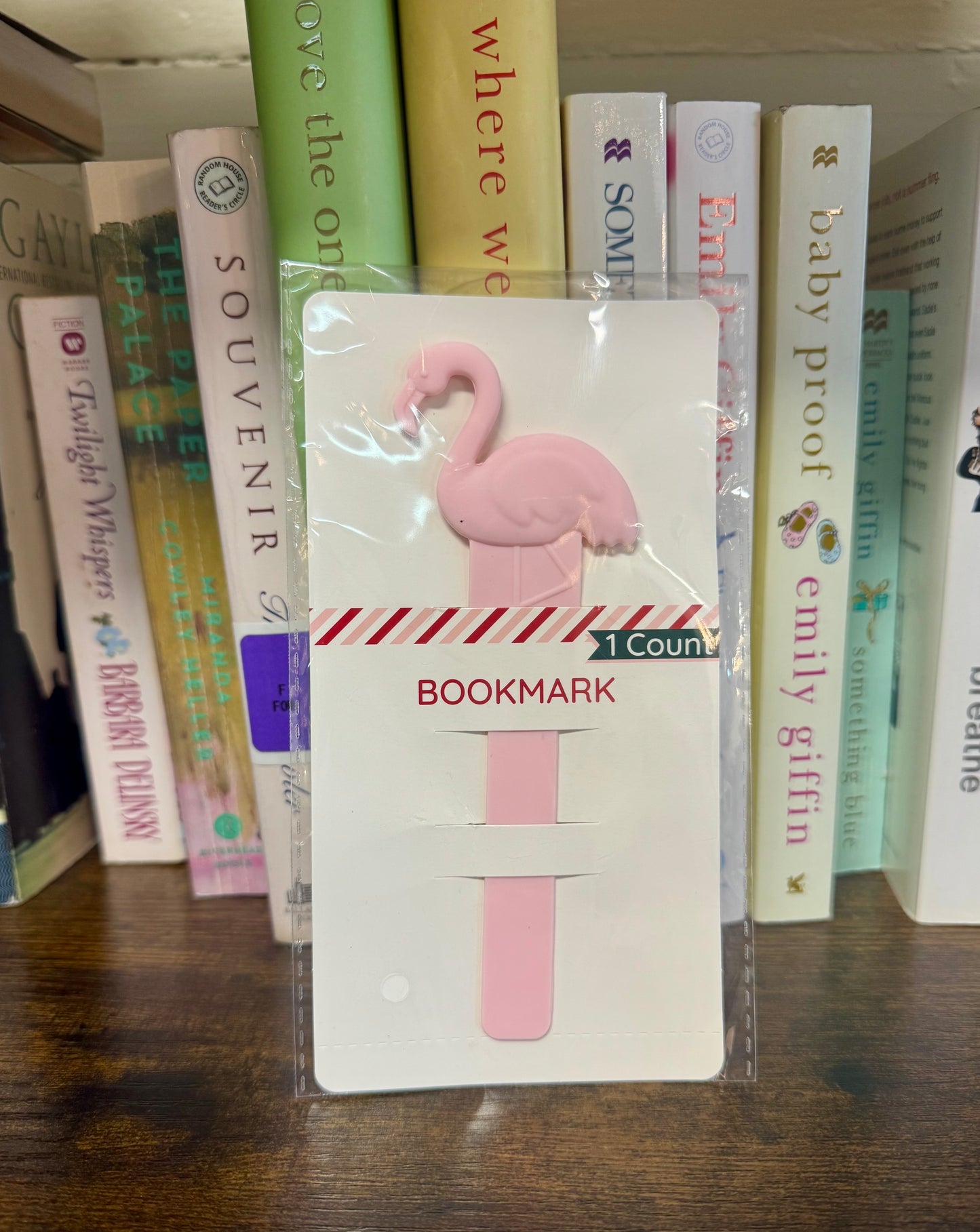 Flamingo-shaped bookmark in packaging with books in the background